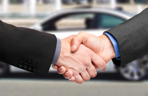 Two men shaking hands after a successful car purchase